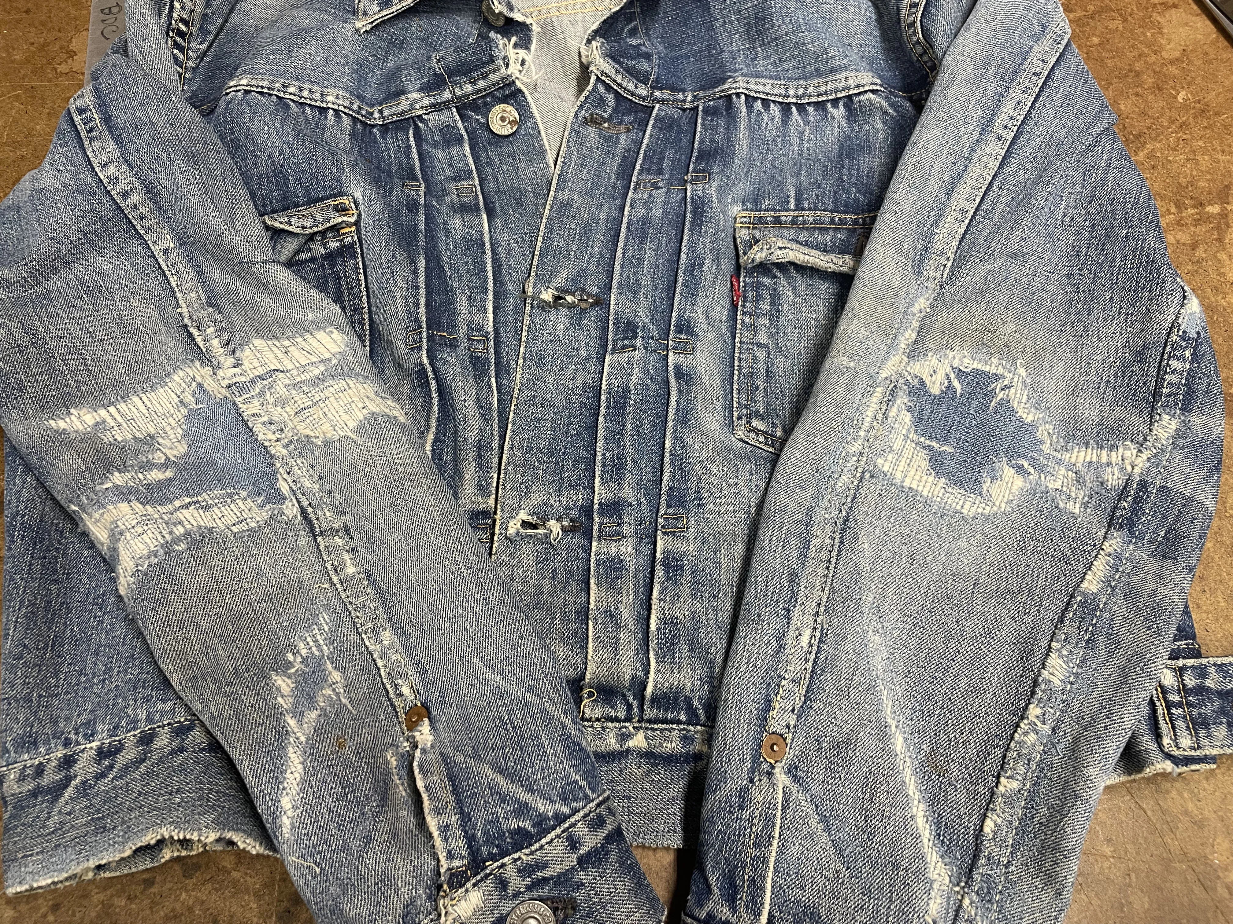 Visible mending on denim jacket